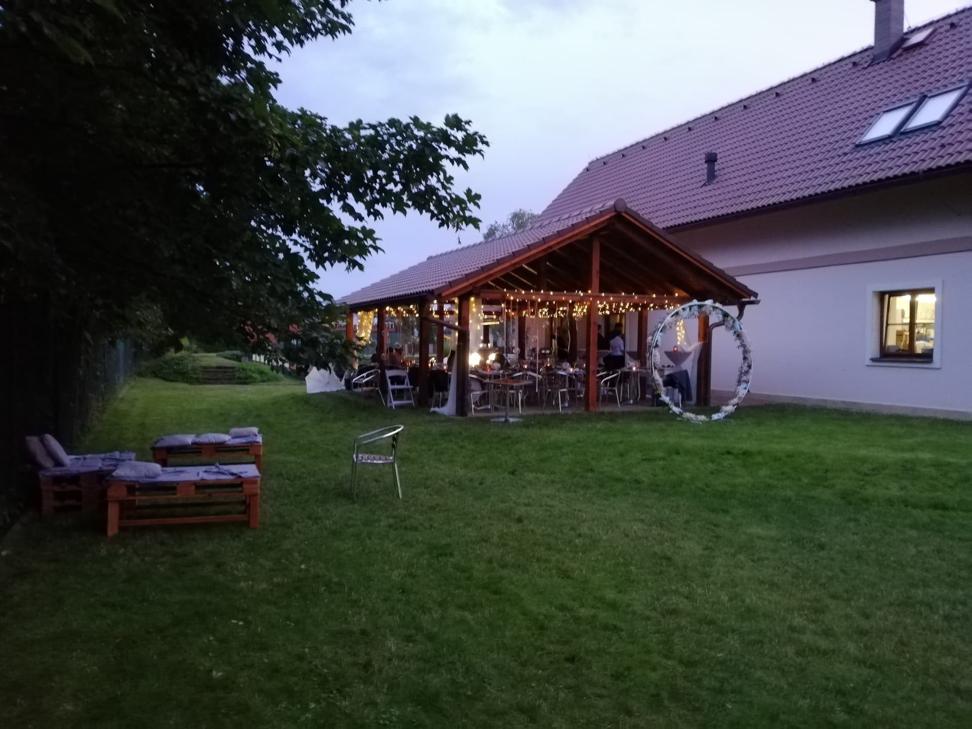 Večerní svatební oslava pod pergolou s osvětlením