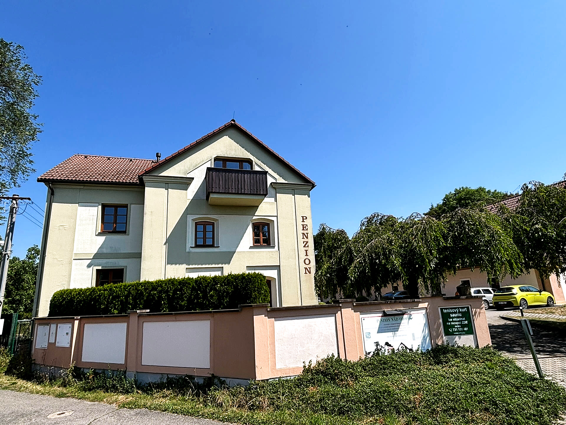 Penzion Nad Oborou od příjezdové cesty s parkovištěm