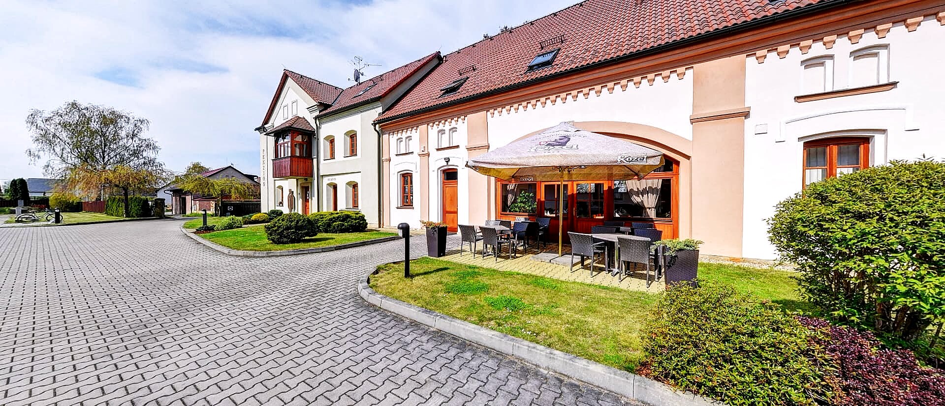 Venkovní posezení před penzionem v zahradě plné zeleně