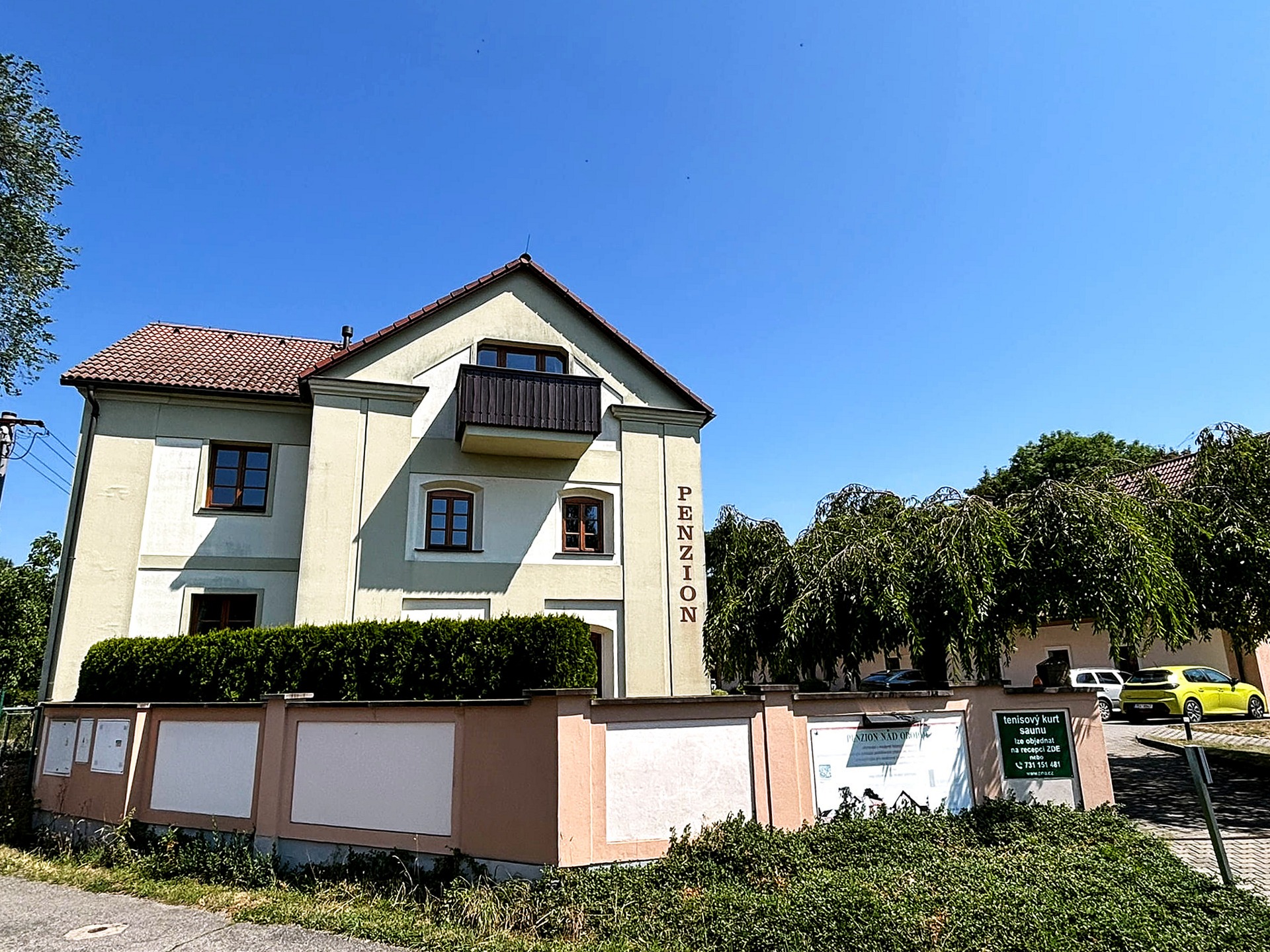 Penzion Nad Oborou od příjezdové cesty s parkovištěm
