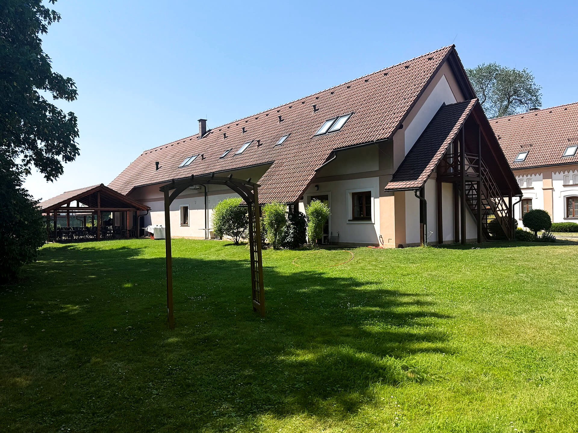 Zahrada s pergolou a travnatou plochou pro rodinné oslavy a svatby