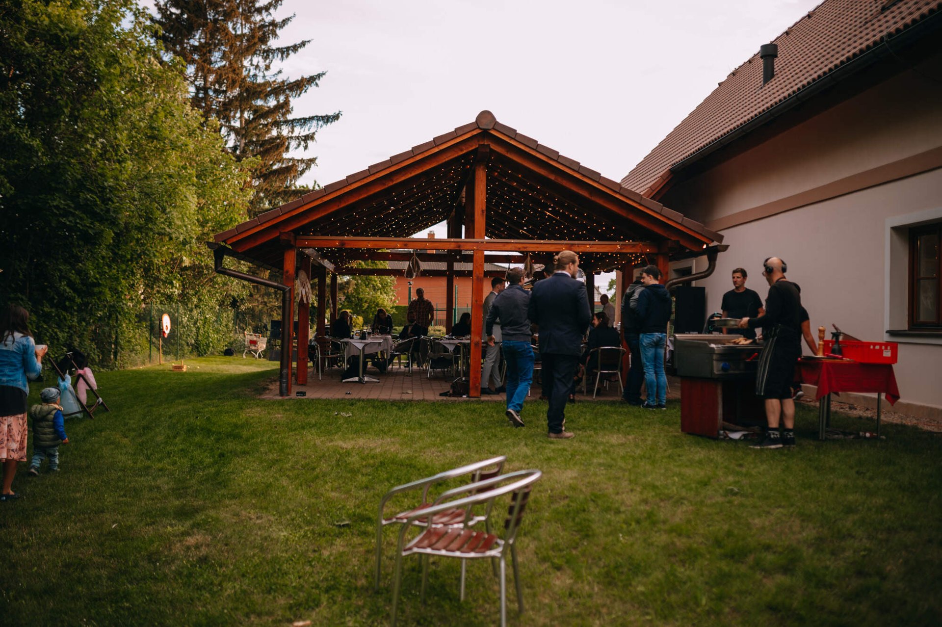 Svatební oslava pod dřevěným altánem s občerstvením