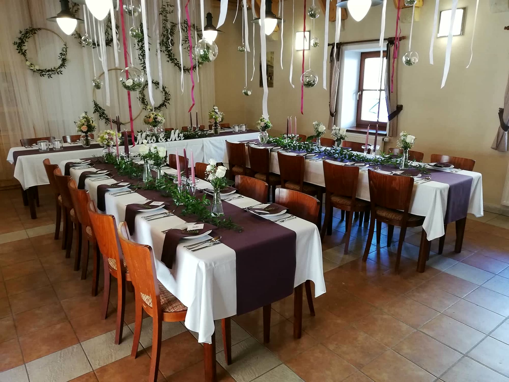 Slavnostní tabule s fialovými běhouny — rodinné oslavy v sále penzionu